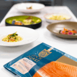 Branded pack of Loch Duart Salmon next to some prepared salmon dishes.